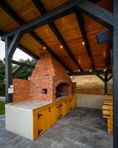 an outdoor kitchen with a brick oven on a patio at Nale Luxury Chalet in Bratunac