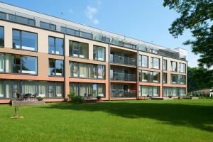 Un gran edificio con césped delante. en Central Apartment, en Birštonas