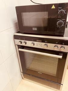 a microwave sitting on top of an oven at 1 Bhk in Abu Dhabi