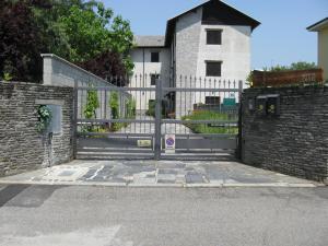 una puerta frente a una casa con una valla en La Bottega Del Falegname, en Vanzaghello