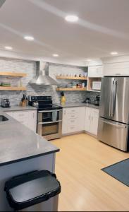 a kitchen with white cabinets and a stainless steel refrigerator at Katama Family Fun in Edgartown +40 photos