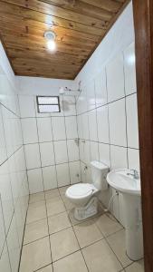 a bathroom with a toilet and a sink at Casa Amplia in Encarnación +5 photos