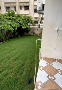 AyodhyaにあるShanta Innの建物のある芝生の庭にある白いベンチ