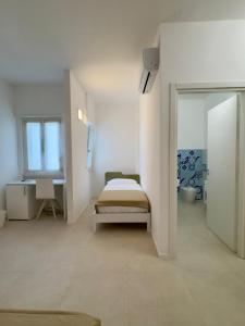 a white room with a bed and a window at Fata Morgana Guest Rooms in Diamante +47 photos