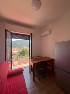 a living room with a table and a red couch at La Terrazza di Paola in Il Romito +17 photos