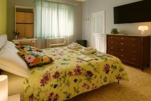 sypialnia z łóżkiem z narzutą w kwiaty w obiekcie Vivi Lucca con "Madame Fannj" - Camera Verde w Lukce +37 zdjęć