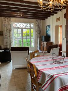 a dining room with a table and a living room at Gite les Flots Bleus in Jullouville-les-Pins