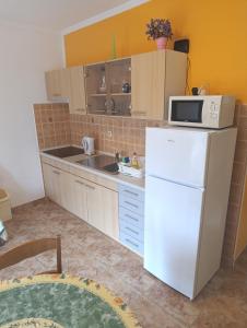 ロパールにあるLopar Maricaの白い冷蔵庫と電子レンジのあるキッチン