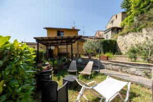 un grupo de sillas y un cenador en un patio en Sebastiano, en Colle Val D'Elsa