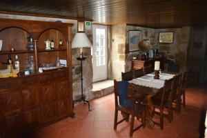 a dining room with a table and chairs and a lamp at Solar dos Correia Alves in Moimenta da Beira