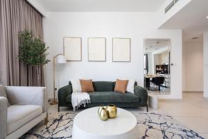 a living room with a couch and a table at Luxury Two Bedroom Apartment with City & Pool View by Delujo Stays in Dubai +47 photos
