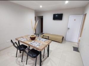 a dining room with a table and chairs and a bedroom at San Clemente Aventura in San Clemente del Tuyú