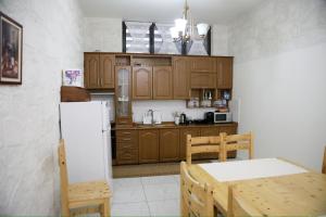 a kitchen with wooden cabinets and a table and a refrigerator at Roan Luxury Villa in Vlorë
