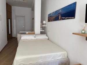 una camera da letto con un grande letto bianco in una stanza di La Casa di Ciui ad un passo da Via Toledo a Napoli