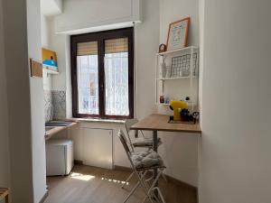 una piccola cucina con tavolo e finestra di La Casa di Ciui ad un passo da Via Toledo a Napoli Altre 14 foto