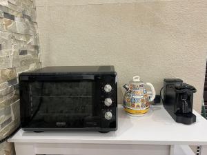 a microwave sitting on a table with a coffee pot at Naxos Room in Giardini Naxos