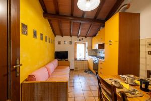 Una cocina con paredes amarillas y un sofá dentro. en Sebastiano, en Colle Val D'Elsa