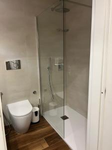 a bathroom with a toilet and a glass shower at Naxos Room in Giardini Naxos +6 photos