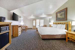 a large hotel room with a bed and a television at Best Western East Zion Thunderbird Lodge in Mount Carmel Junction