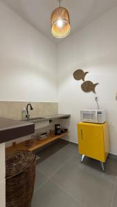 a kitchen with a sink and a yellow cabinet at O Caminho das Dunas in Jericoacoara +12 photos