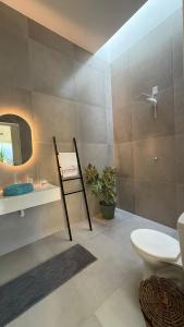 a bathroom with a toilet and a sink and a mirror at O Caminho das Dunas in Jericoacoara