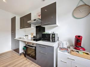 a kitchen with a microwave and a stove top oven at 2 appartements réunis 6 chambres parking 16 pers in Aubière +13 photos