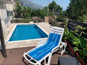 a white chair sitting next to a swimming pool at Villa DanDan Sutomore in Zagrađe