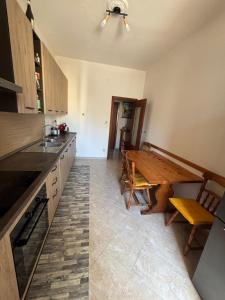 a kitchen with a wooden table and a dining room at SebHouse in Alghero +3 photos