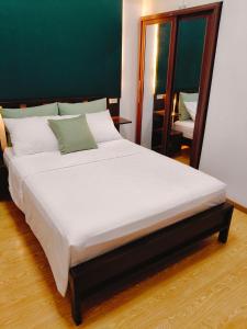 バギオにあるCEDAR PEAK by AWESOME STAY in Baguioの鏡付きの客室内の大きな白いベッド