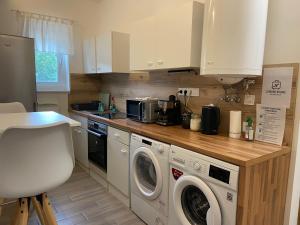 a kitchen with a washer and dryer in it at Landing Rooms Apartman in Üllő