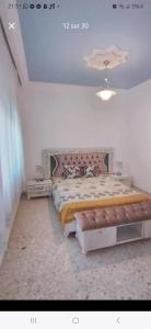 a bedroom with a bed with a bench in it at Sidi mahrsi Nabeul in Nabeul