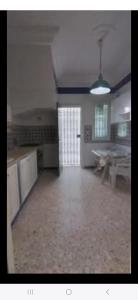 a large empty room with a kitchen and a table at Sidi mahrsi Nabeul in Nabeul