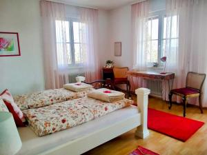 a bedroom with two beds and a desk and windows at Ferienwohnung Panoramablick Freudenstadt in Freudenstadt