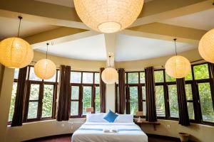 een slaapkamer met een bed en enkele verlichting en ramen bij Krazy Gecko Resort in Pokhara