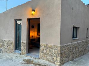 a building with a stone wall and a doorway at casa rural El Valle del Calar in Riópar