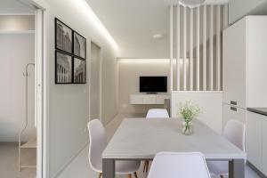une salle à manger avec une table et des chaises blanches dans l'établissement Vatican Suites, à Rome