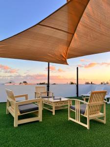 a group of chairs sitting under a large umbrella at Amazing Sunset view rooftop. in Flic-en-Flac