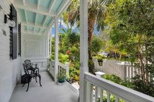 a porch with a chair and a palm tree at Island Time Casa Modern Key West Oasis W- Pool in Key West