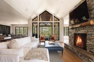 Luxury Ridgecrest Resort 4BR في بيغ بير لاكي: غرفة معيشة مع أريكة بيضاء ومدفأة