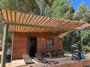 a wooden cabin with chairs and a grill on a deck at La Tiny du Luberon in Pertuis
