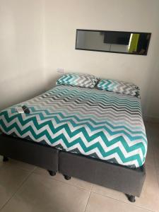 Una cama con dos almohadas encima en una habitación. en Azul caribe 101, en Santa Marta