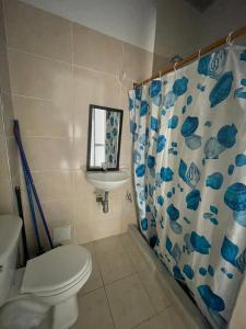 Un baño con inodoro, lavabo y espejo. en Azul caribe 101, en Santa Marta