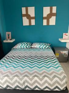 Un dormitorio con una cama con una pared azul. en Azul caribe 101, en Santa Marta