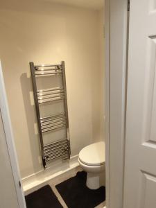 a bathroom with a toilet and a towel rack at En-Suite Double-Bedroom in the Heart of Salford Manchester CR2 Perfect for Short Stays in Manchester