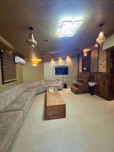 a large living room with a couch and a tv at KORAMANGALA SUITEs in Bengaluru