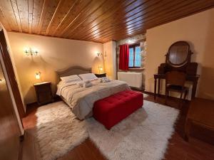 a bedroom with a large bed and a red couch at Villa Acroria in Karpenisi in Karpenisi