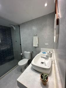 a bathroom with a white sink and a toilet at Pousada Makai in Porto De Galinhas +41 photos