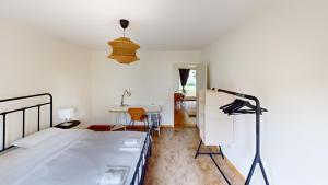 a white room with a bed and a table at Comfortable Living in a 3-Bedroom Space in Zürich