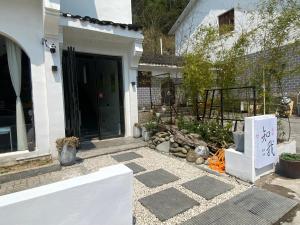 TaipingZhiwo B&B Fanjingshan East Branc的一座带院子的白色房子的前门