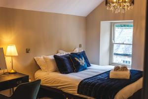 a bedroom with a bed with blue pillows and a window at The Library Suite in Marske